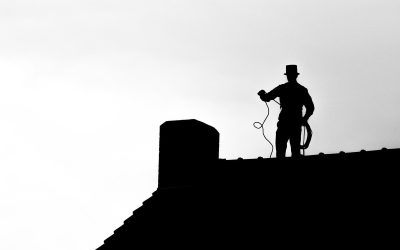 Silhouette d'un ramoneur sur toit, chapeau haut, corde à la main