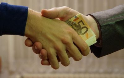 Homme en costume et homme en pull serrant la main avec des billets de 50 euros