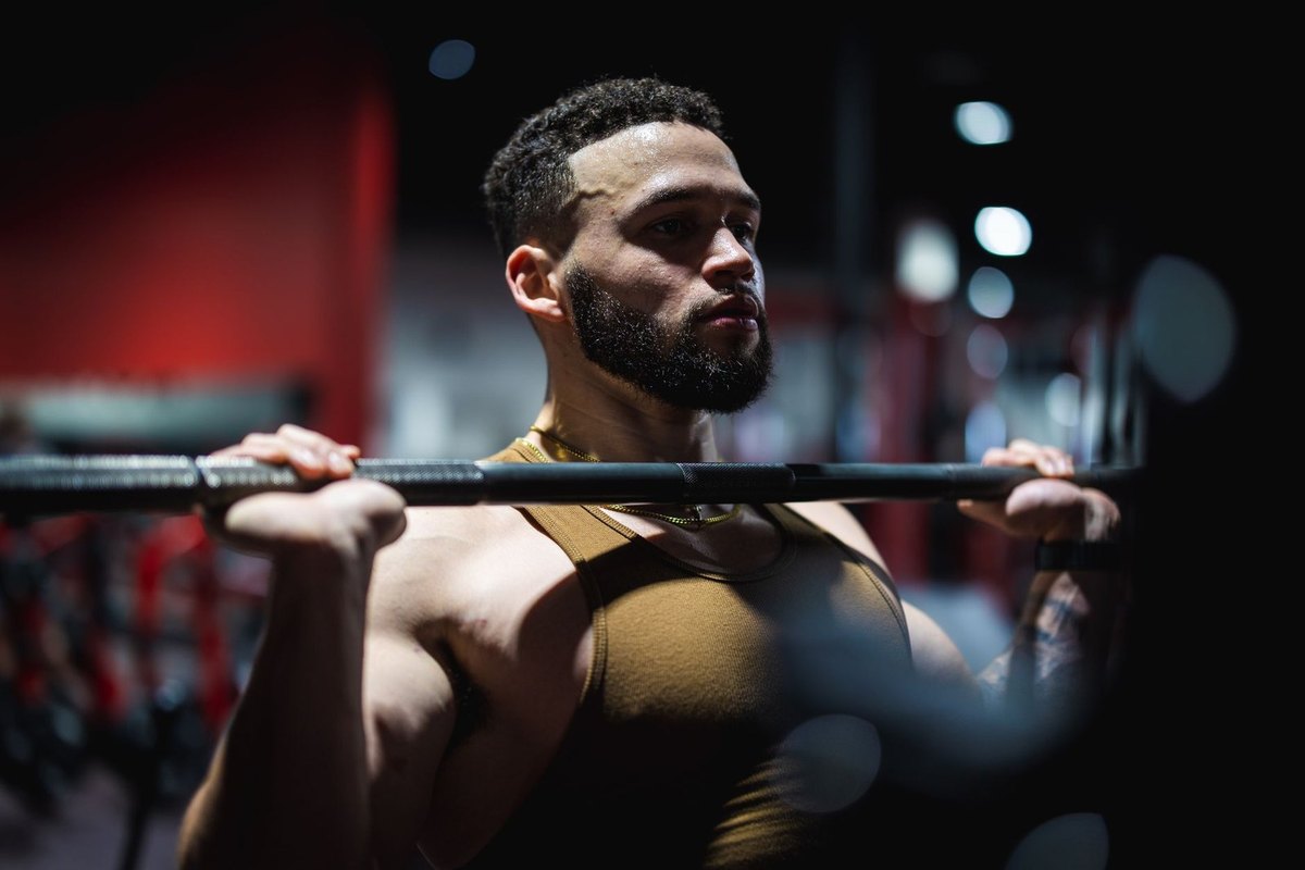 Homme musclé soulevant barre en salle de sport